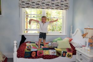 boy jumping on doffie designed bed